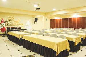 una sala de conferencias con mesas, sillas y un escenario en Hotel B&V en Huancayo