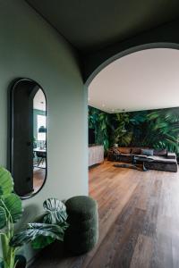 a living room with a large mirror and a couch at Exklusive Design Appartement Palm Paradise Neubau in Pfungstadt