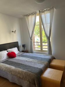 Un dormitorio con una cama grande y una ventana en Au Coeur de Meaulne, en Meaulne