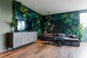 a living room with a large mural of plants at Exklusive Design Appartement Palm Paradise Neubau in Pfungstadt