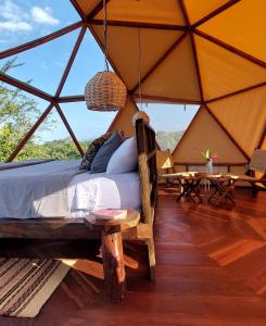 a bedroom in a tent with a bed and tables at Glamping - Habla con la Luna in Santa Marta