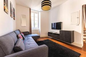 a living room with a couch and a tv at Maison au cœur de Valence avec parking privé in Valence