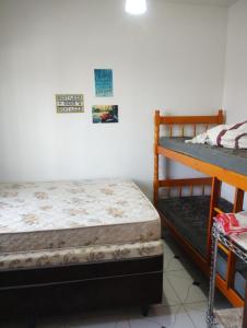 a bedroom with two bunk beds in a room at Casa Arejada 300mts do mar in Guaratuba