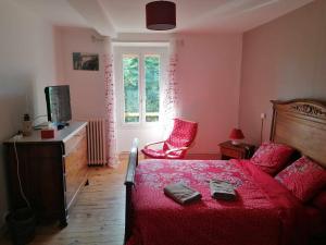 a bedroom with a bed and a chair and a window at Ferme les poneys de la Durme in Chélieu