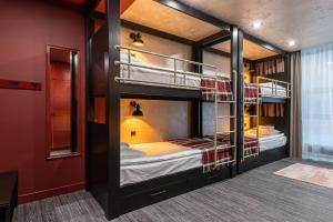 two bunk beds in a room with red walls at Emily Magic Hostel in Vynnyky