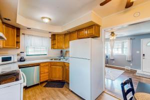 a kitchen with wooden cabinets and a white refrigerator at Neverending Beauty in Glens Falls