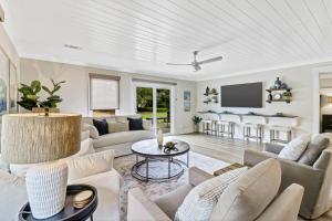 a living room with white furniture and a flat screen tv at 672 Queens Grant in Hilton Head Island