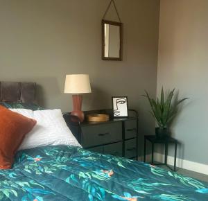 um quarto com uma cama com um candeeiro e uma cómoda em The Gainsborough Mews-stylish & modern (sleeps 3) em Lincolnshire