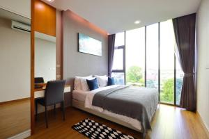 a bedroom with a bed and a desk and a window at Stunning Spacious Mountain View Apartment in Chiang Mai