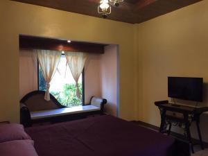 a bedroom with a bed and a window with a television at Sweet Inn Resort in Bang Pahan