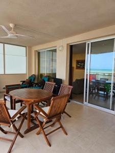 uma sala de estar com uma mesa de madeira e cadeiras em Edificio Mondrian 1ª Linea vistas al mar em Oropesa del Mar