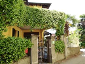 a yellow house with a gate with ivy on it at Bed and Breakfast da Pio in Castelveccana