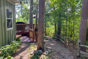 a house with a deck in the woods at Lucy Lake Lookout in Lac du Flambeau