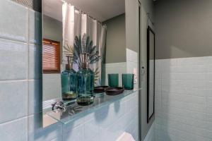 a bathroom with a glass shelf with vases on it at Les Cantinières - Bourgoin Jallieu - Jardin Privé in Ruy +26 photos