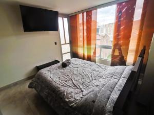 ein Schlafzimmer mit einem Bett und einem großen Fenster in der Unterkunft Nuevo apartamento en sector industrial y deportivo in Sogamoso