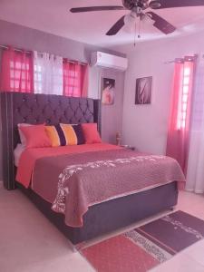 - une chambre avec un grand lit rose et violet dans l'établissement Hermoso Apto. en Bani, Rep. Dom., à Baní