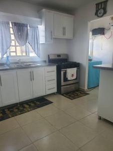 uma cozinha com armários brancos e um forno com placa de fogão em Hermoso Apto. en Bani, Rep. Dom. em Baní