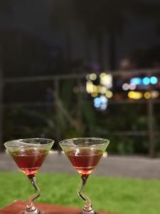 two glasses of wine sitting on a table at ShearaZ Castle in Kāyankulam