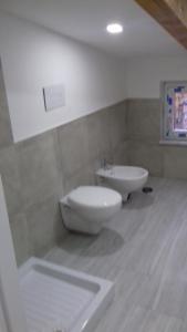 ein Badezimmer mit einem weißen WC und einem Waschbecken in der Unterkunft Attico 3 in Eboli