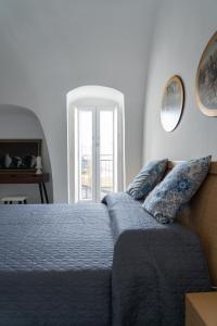 een slaapkamer met een bed, een bank en een raam bij La Corte di Navarrete in Laterza
