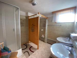a bathroom with two sinks and a shower at Bauernhof Helpferer in Ramsau am Dachstein
