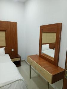 a bedroom with a mirror on a dresser next to a bed at فندق قصر اباهي 3 in Buqayq +3 photos
