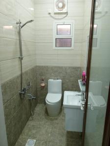 a bathroom with a toilet and a sink and a shower at فندق قصر اباهي 3 in Buqayq