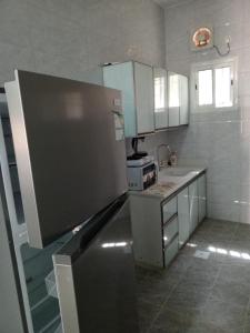 a kitchen with a refrigerator and a stove in it at فندق قصر اباهي 3 in Buqayq