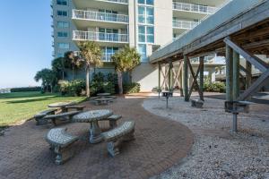 een patio met picknicktafels en banken voor een gebouw bij Tristan Towers unit 10A in Pensacola