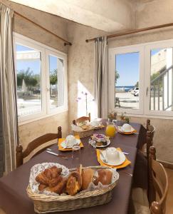a table with a table with bread and windows at Hotel St Joseph in Algajola
