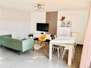 a living room with a couch and a table at BtoBed - Le Chic Villepintois\Parking Gratuit in Villepinte