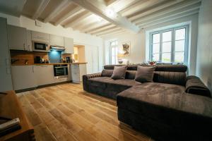 sala de estar con 2 sofás y cocina en Les Pinsons, en Montigny-le-Gannelon