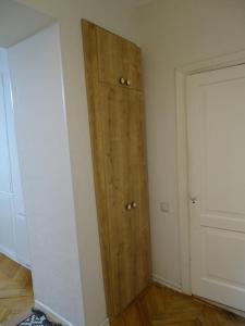 a room with a wooden cabinet next to a door at Vake Super Quiet and Comfy Apartment with a Yard in Tbilisi City