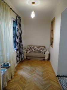 a living room with a couch and a window at Vake Super Quiet and Comfy Apartment with a Yard in Tbilisi City