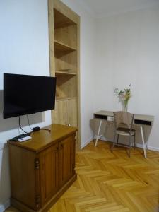 a living room with a television on a wooden cabinet at Vake Super Quiet and Comfy Apartment with a Yard in Tbilisi City