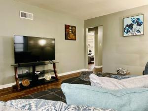 sala de estar con 2 sofás y TV de pantalla plana en Central Chic on Washington, en Evansville