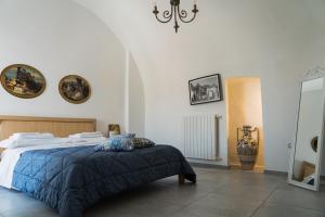een slaapkamer met een bed en een kroonluchter bij La Corte di Navarrete in Laterza