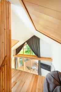 an attic room with a large window and wooden floors at Terra Resort in Topliţa