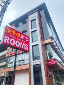 a building with a red sign in front of it at Redbell Suites Kizhisseri in Kondotti +21 photos