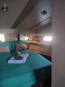 a bed in a boat with a green blanket at Yach Boat Experience in Barcelona
