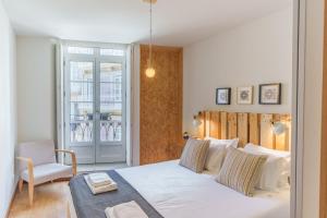 1 dormitorio con 1 cama, 1 silla y 1 ventana en OX Apartments Taipas, en Oporto