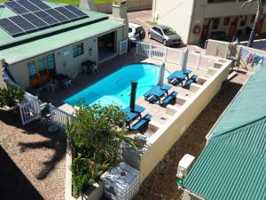 an overhead view of a swimming pool with chairs and a building at Hexberg Cottage in Wellington