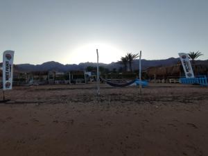 a playground with a hammock on a sandy beach at White palace camp (ex camp David) in Nuweiba