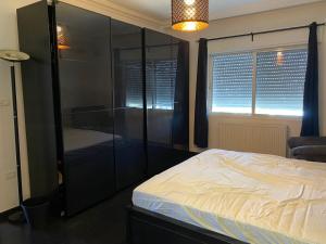 a bedroom with a bed and a large glass closet at Prime apartment with amazing view in Amman in Amman