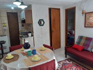 uma sala de estar com uma mesa e um sofá vermelho em Casa condomínio paz em Petrópolis