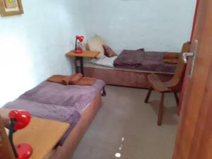 een kamer met 2 bedden, een bureau en een stoel bij Casa condomínio paz in Petrópolis