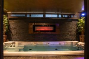 a bath tub in a room with a fireplace at Suite Wellness in Sprimont