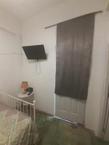 a bedroom with a window with a black curtain at La casa jokay 2 in Santo Domingo