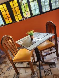 a table and chairs in a room with windows at Casa Mandarina San Luis in La Punta