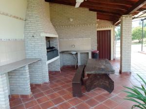 una cocina al aire libre con mesa de madera y banco en Mi Refugio La Herencia, en Caacupé